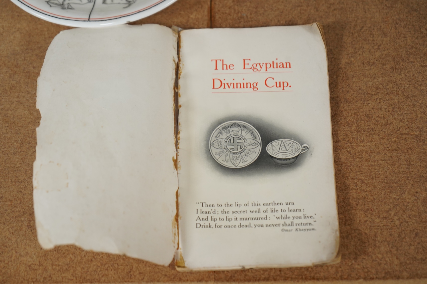 A Royal Doulton 'The Egyptian Divining cup and saucer', with booklet, numbered RN543665